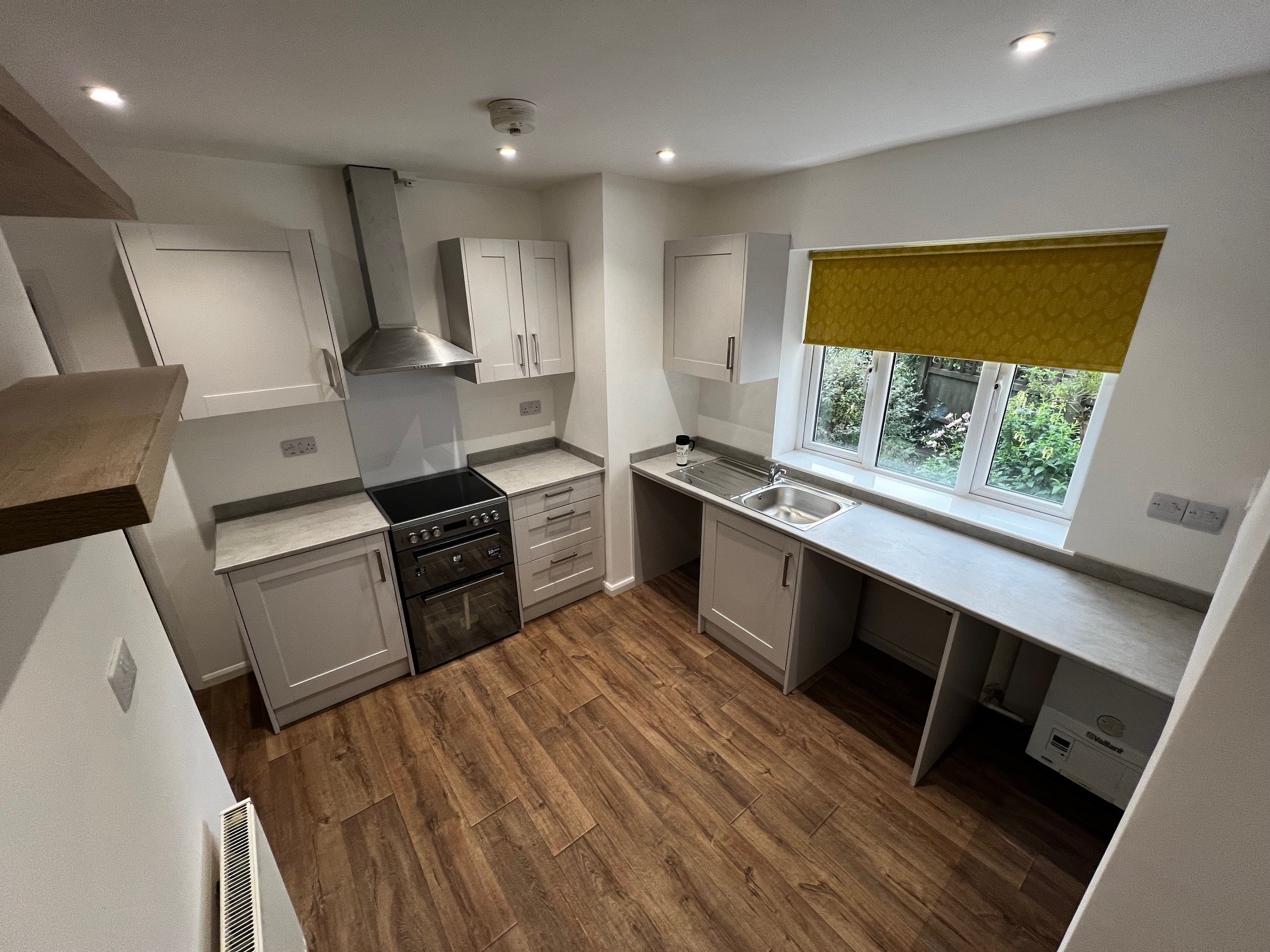 Kitchen installation with tiled splashback fitted cabinets, worktop, and appliances